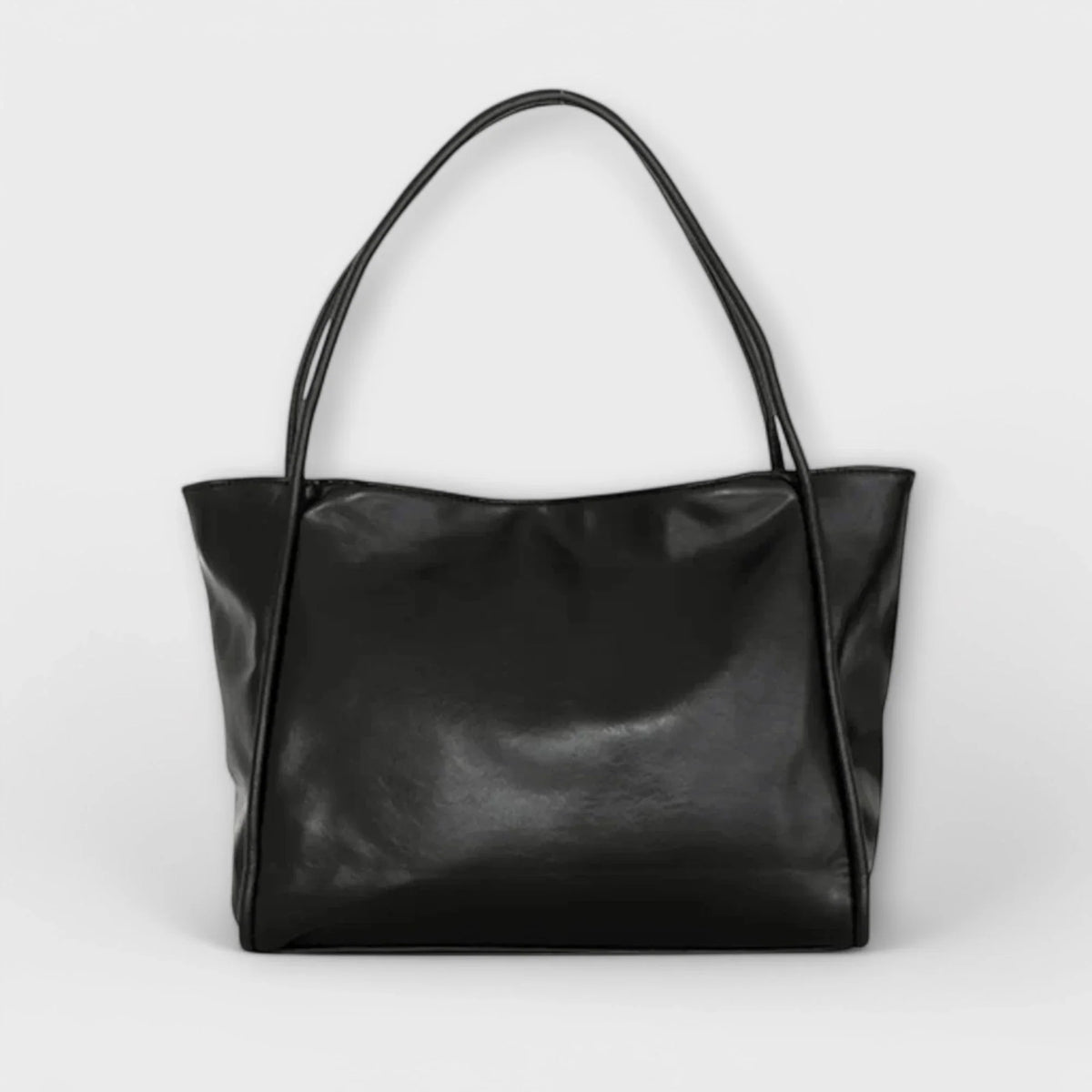 Black faux-leather tote bag with open-top and thin shoulder straps.