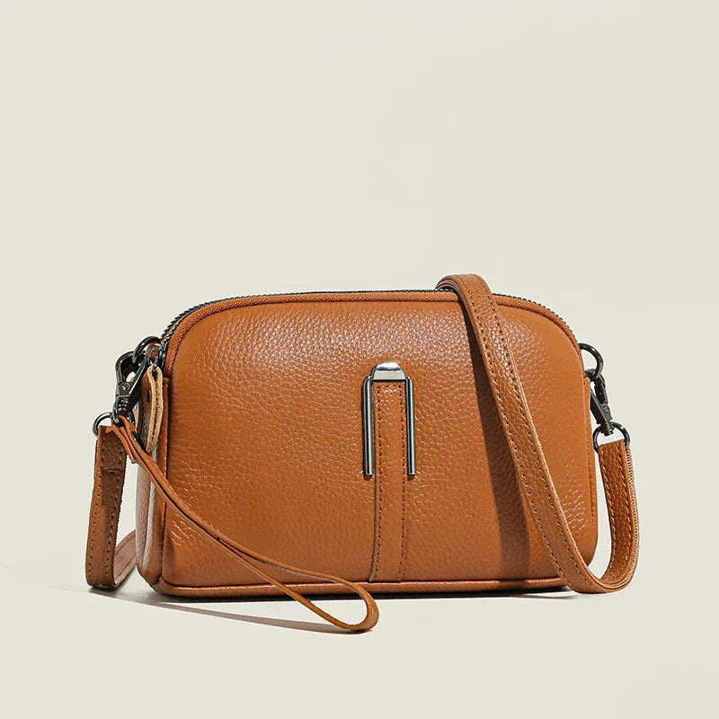 Brown leather shoulder bag, double zip, metal accent.