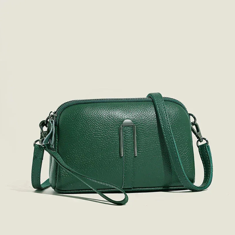Green leather shoulder bag with double top zip closure and metal accent.