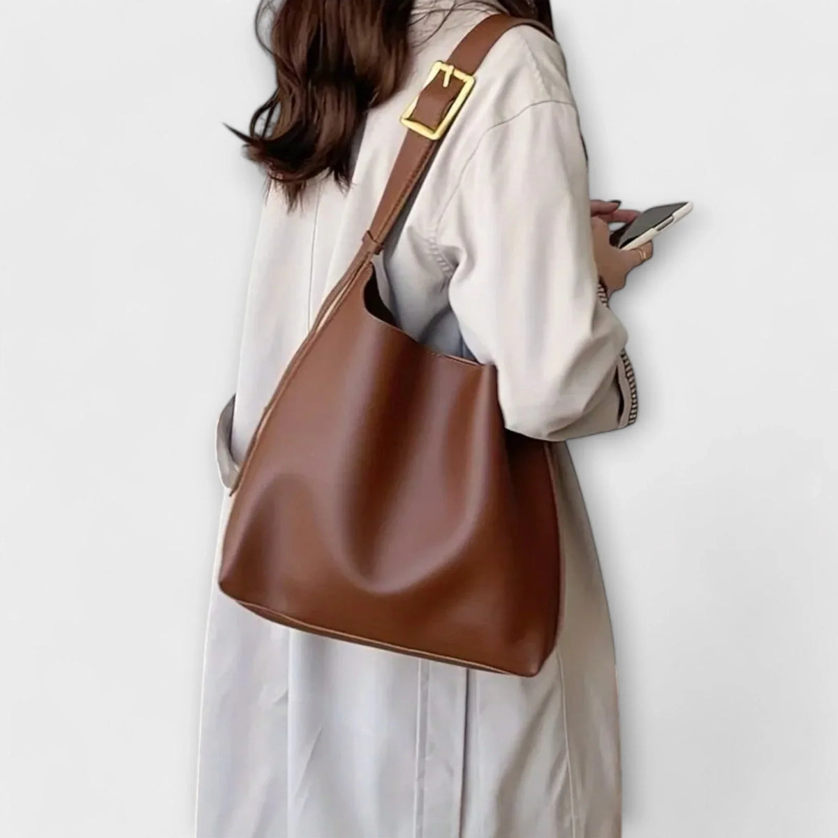 Brown faux leather hobo shoulder bag with adjustable buckle strap.
