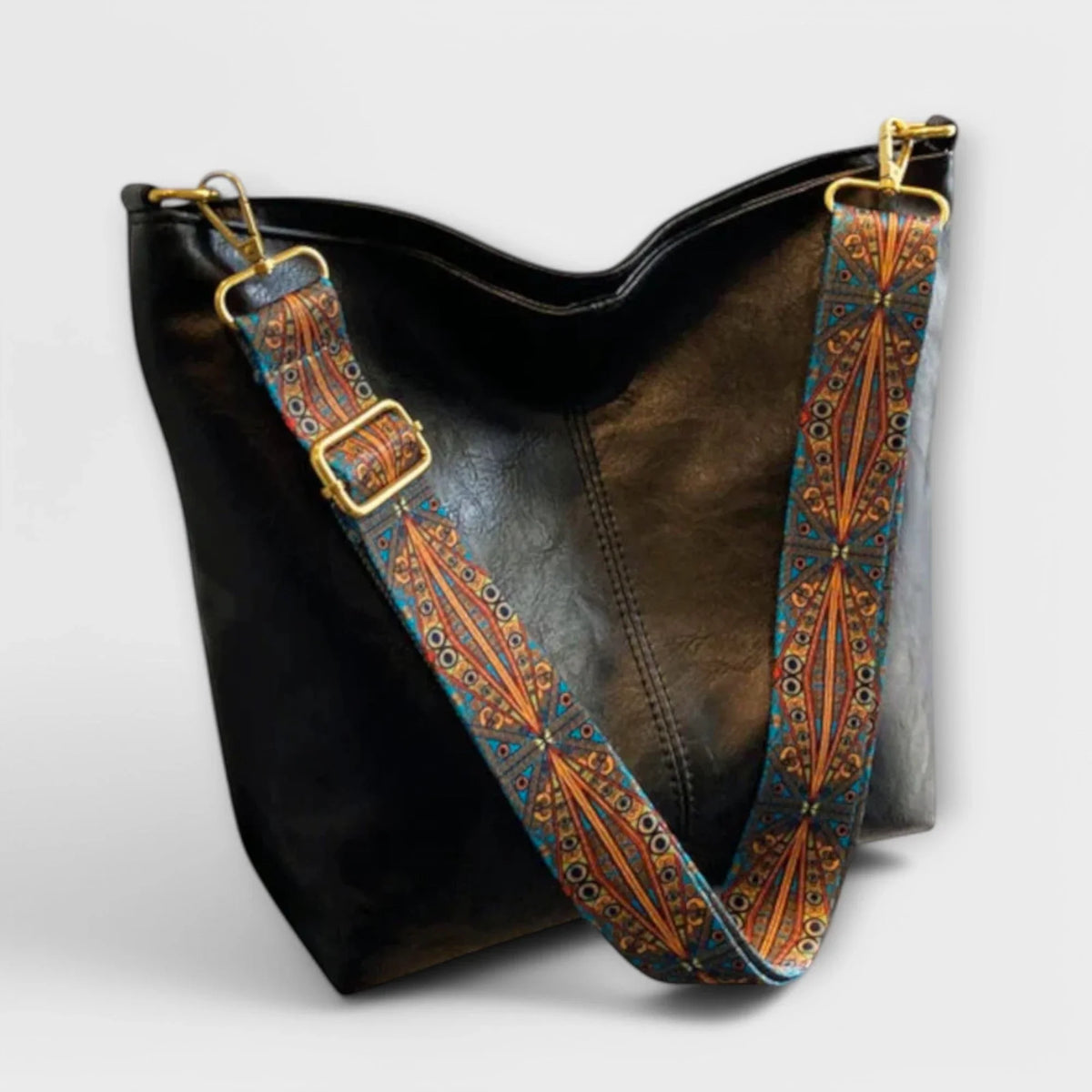 Black faux-leather hobo bag with wide geometric strap.