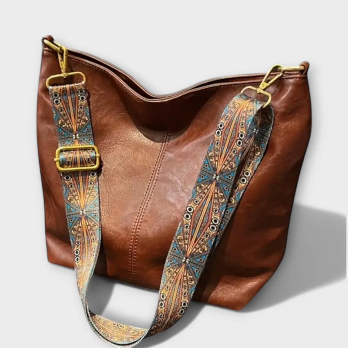 Brown faux-leather hobo shoulder bag with wide geometric strap.