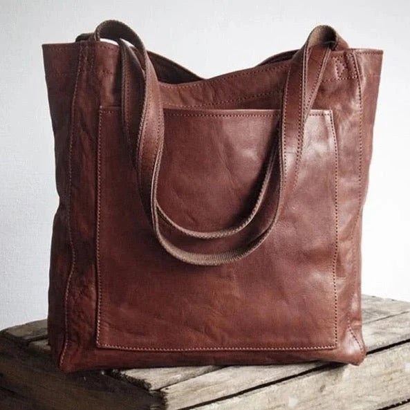 Dark brown leather tote bag with magnetic snap closure and front patch pocket.