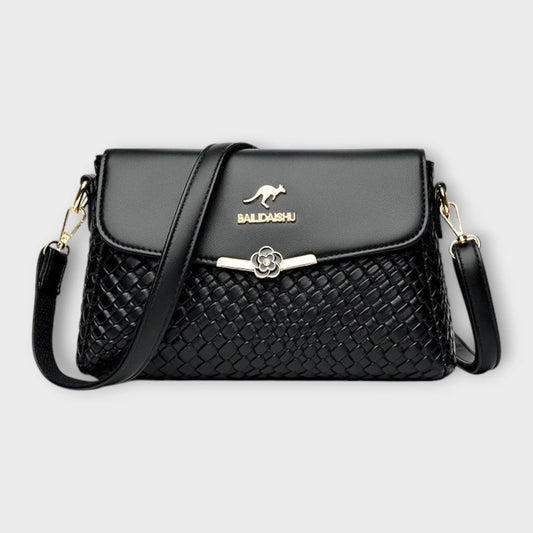 Black faux leather shoulder bag with woven texture, flap closure, and adjustable strap.