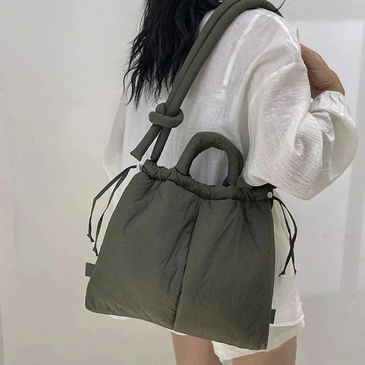 Quilted puffer tote bag with drawstring sides and knot-detail strap.