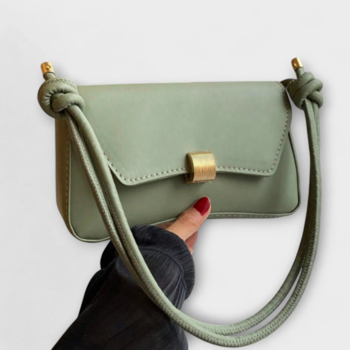 Solid faux leather shoulder bag with flap and knotted strap.
