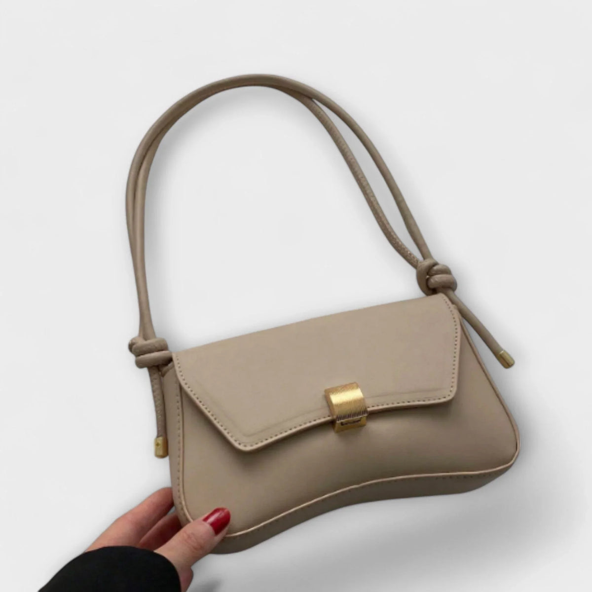 Terracotta faux leather shoulder bag with flap closure and a knotted strap.