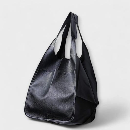 Black faux leather tote bag with two exterior slip pockets.