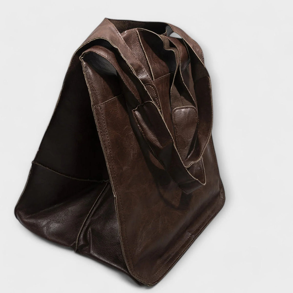 Black faux leather tote bag. Spacious, with two exterior slip pockets.
