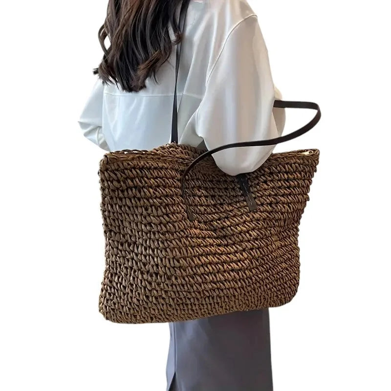Spacious woven straw tote bag with dual faux-leather straps.