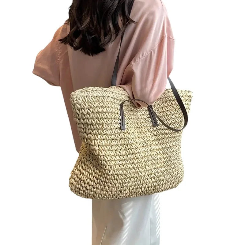 Large woven straw tote bag with double faux-leather straps.