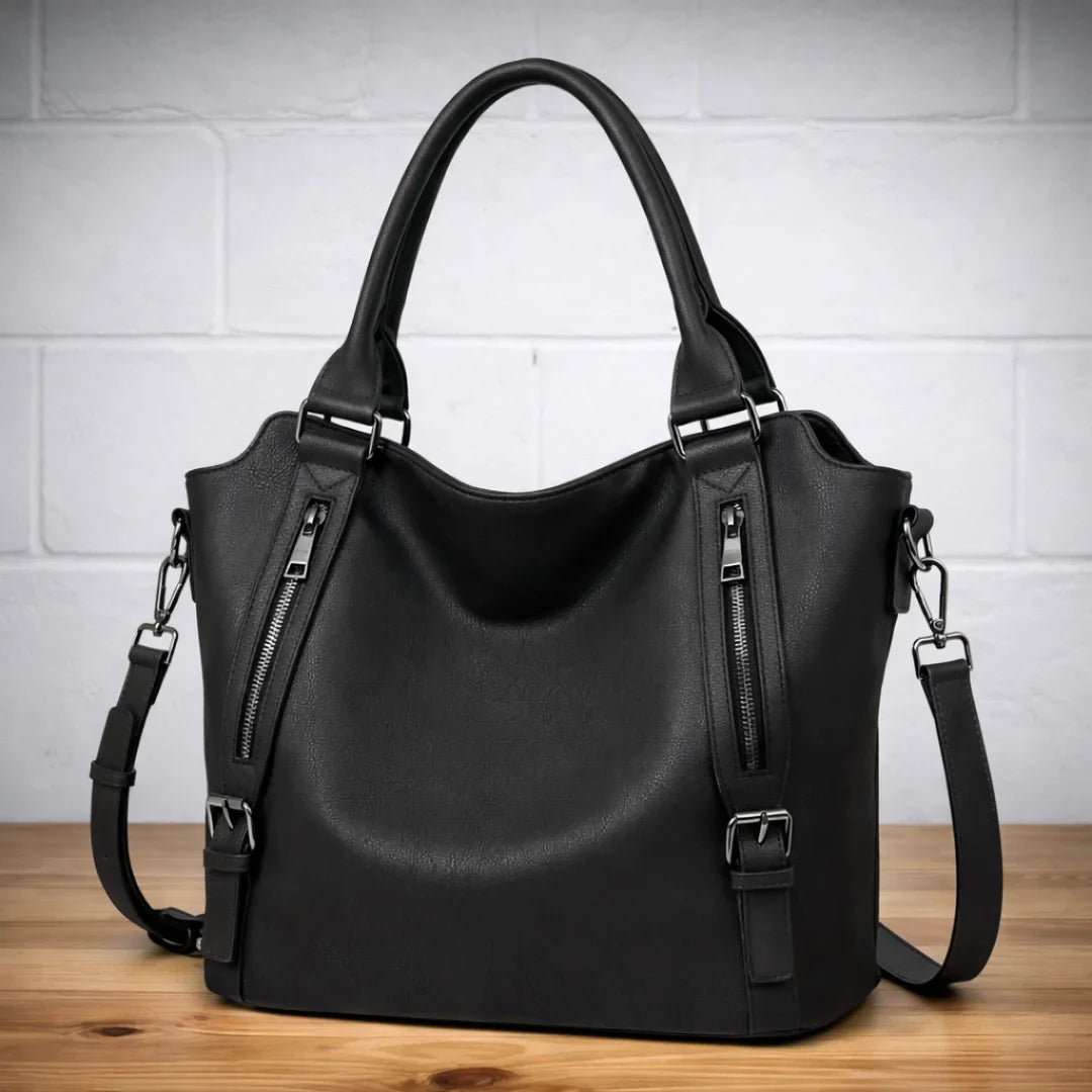 Black slouchy faux-leather crossbody shoulder bag with dual zip pockets.