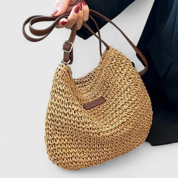 Woven straw hobo shoulder bag with adjustable faux-leather strap.